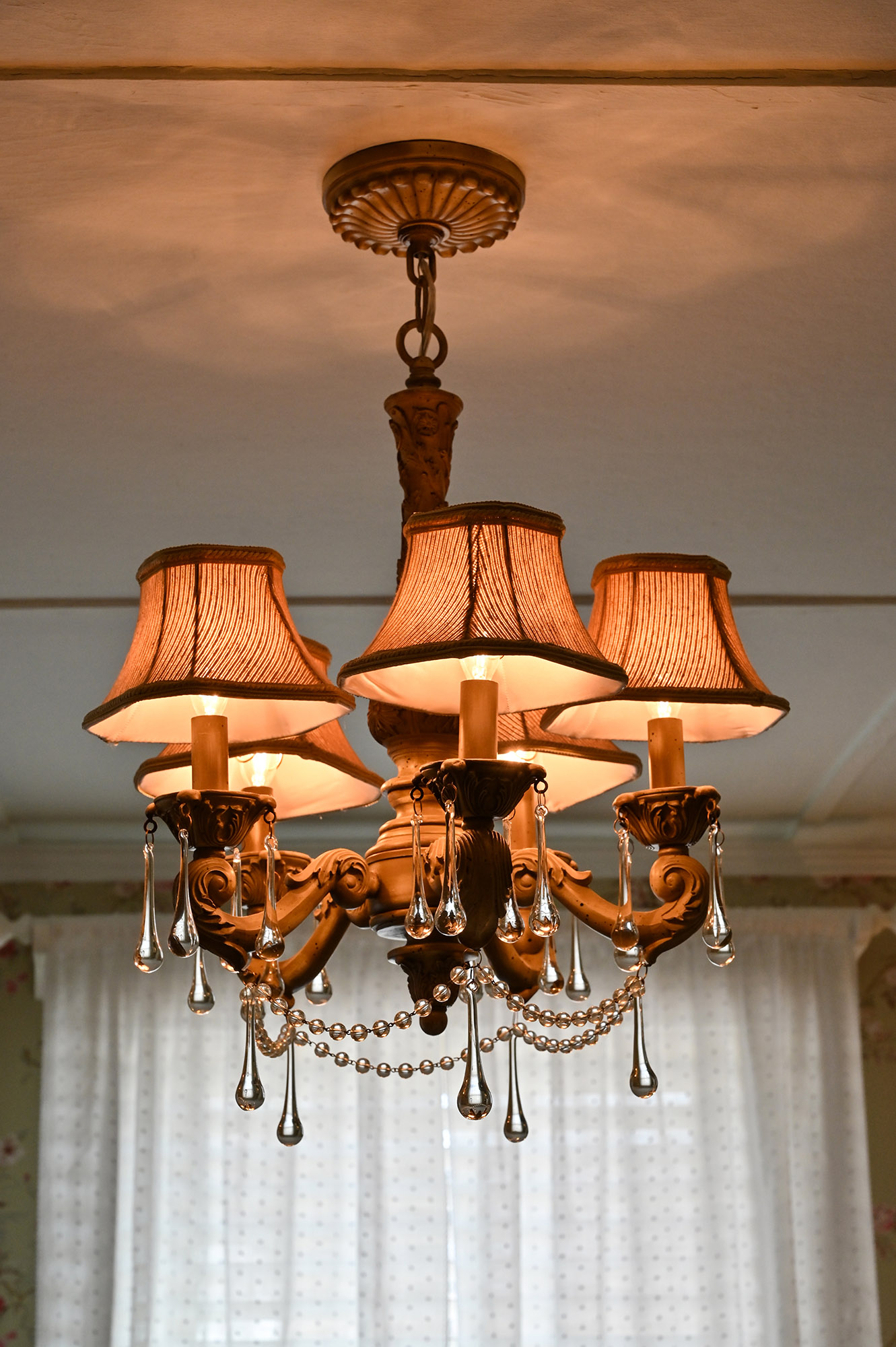 5 light chandelier with shades and jewels hanging from the bottom. Window in background