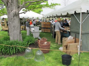 tents in grass field with baskets and antiques