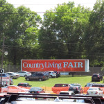 Orange sign in field parking lot says Country Living Fair